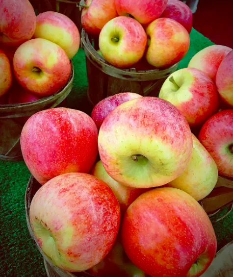 Red and green apples piled in market baskets